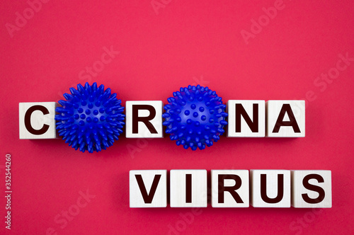 Corona virus, inscription on wooden cubes with a model of the virus on a red background. Like the MERS CoV or SARS virus, severe acute respiratory syndrome. Healthcare and medical concept.
