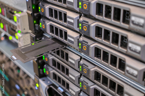 Computer equipment works in the server room of the data center. Array of database servers with many hard drives and service tag. Front panel of the network router. Selective focus