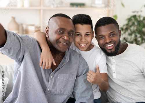 Smiling Senior Black Man Taking Selfie With Son And Grandson At Home