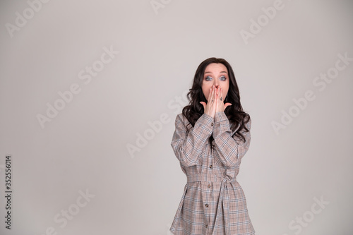 Beautiful girl student business woman surprised on grey background