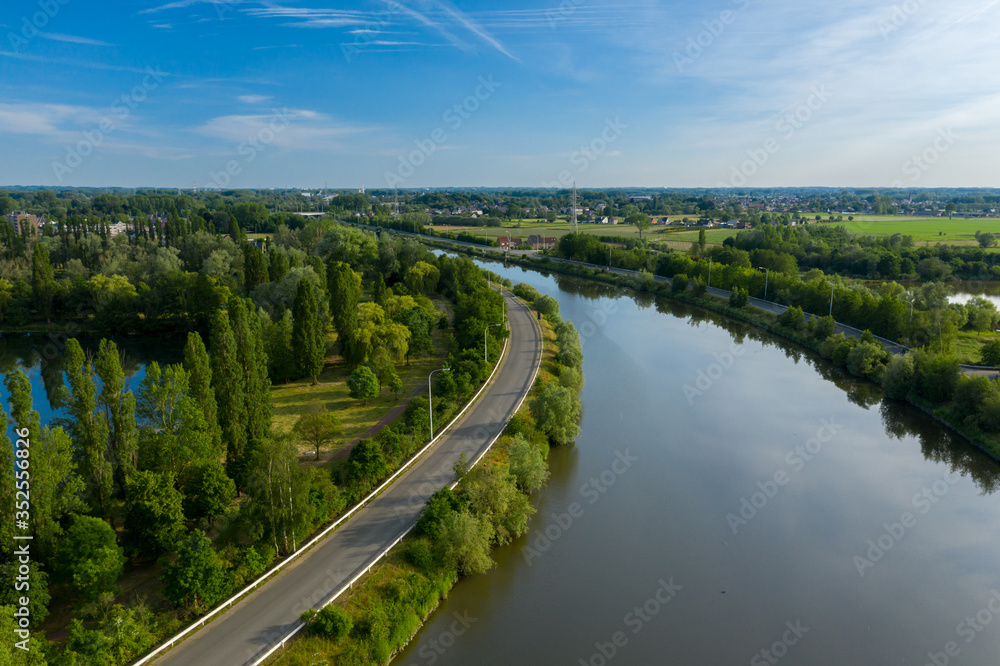 Aerial view of a curved section of the Dender river, while passing the town of Dendermonde, in Belgium
