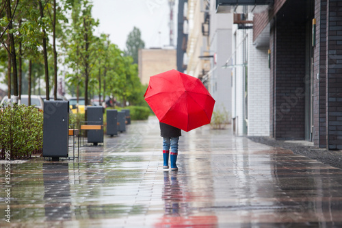 The boy walks in the pouring rain