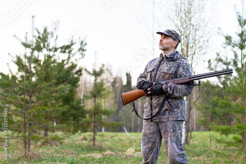hunter with a shotgun waiting for the arrival of game