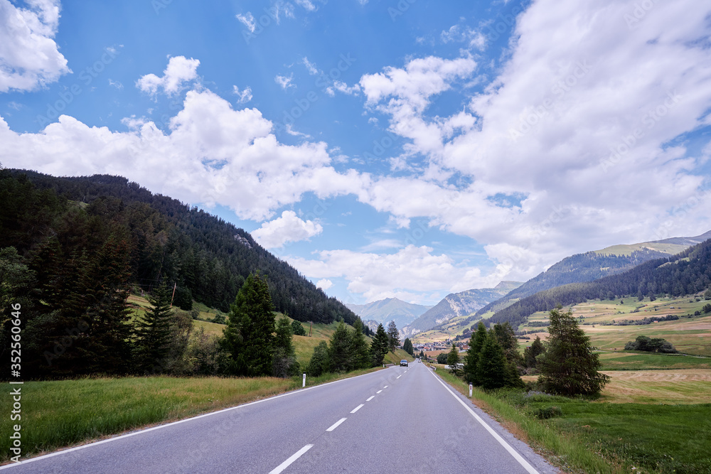 Asphalt road in Alps mountains. Road trip concept.