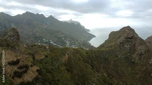 Aerial view of green mountain hills with built-up villas luxury for seasonal rent, housing surrounded by green trees on an island in Spain. Footage from the high point. Bright, daytime
