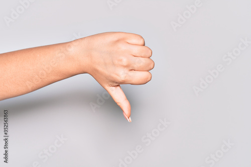 Hand of caucasian young woman doing thumbs down rejection gesture, disapproval dislike and negative sign