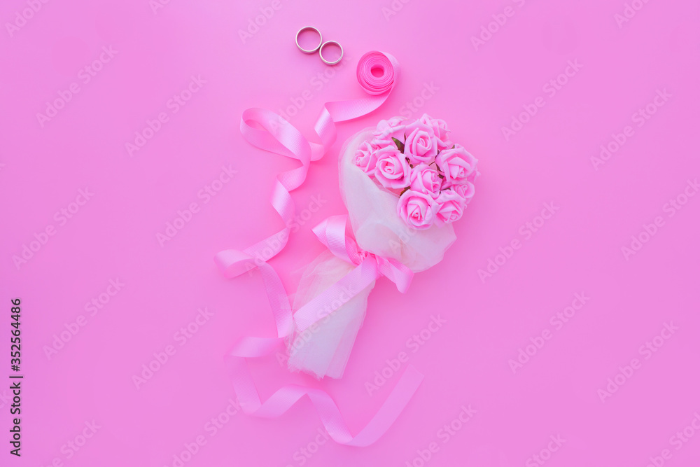 Wedding background top view of the bride's bouquet of pink roses and pink ribbon. Concept delicate female backgrounds or photos for a wedding. Wedding background top view of the bride's bouquet of pink roses and pink ribbon. Concept delicate female backgrounds or photos for a wedding.