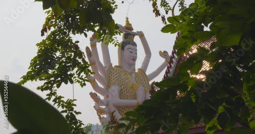 Imposing Hindu Goddess Kali Meditates Peacefuly while Nature Dance Around her in Thailand, Daylight 4K photo