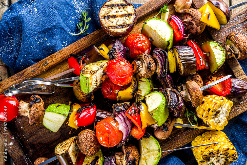 Vegan barbecue party fest concept. Whole vegetable diet kebabs set of various vegetables on skewers. Grilled vegetables on skewers - zucchini, tomato, pepper, eggplant, mushrooms, with sauces