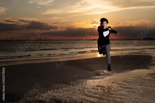 business woman running at sunset on the beach