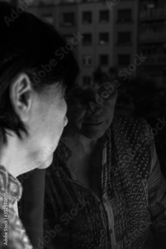 Creative picture with the old woman close the window in corona virus time