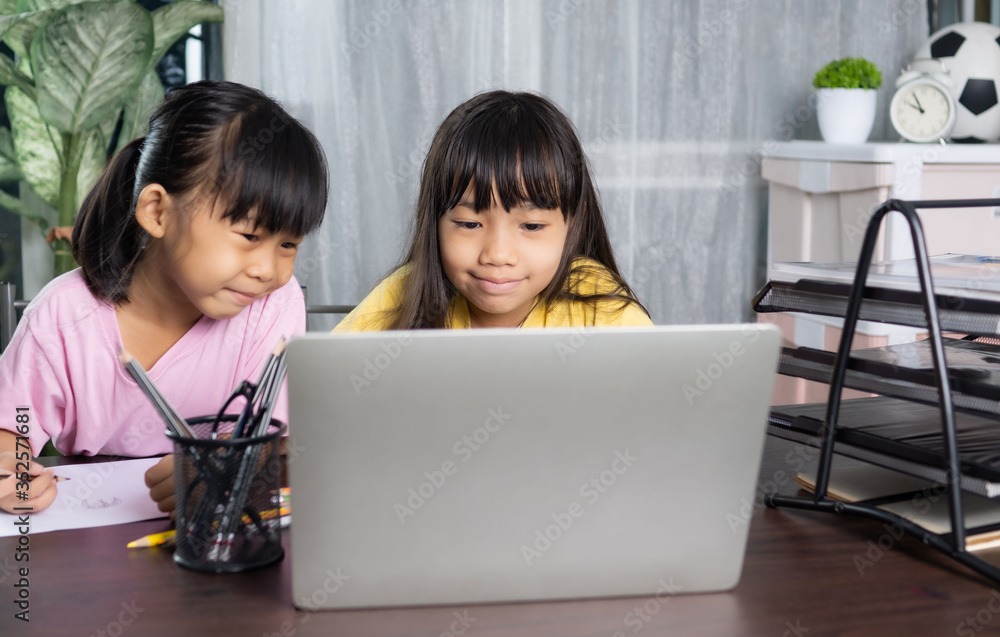 Younger and older sister study and learning online at home, education and knowledge concept Younger and older sister study and learning online at home, education and knowledge concept