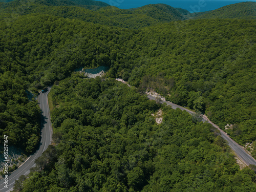 Mountain winding zig zag road. Top aerial view: cars driving on road from above.