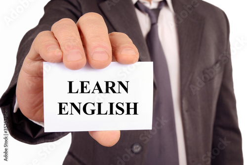 Man holding a card on which is written Learn English
