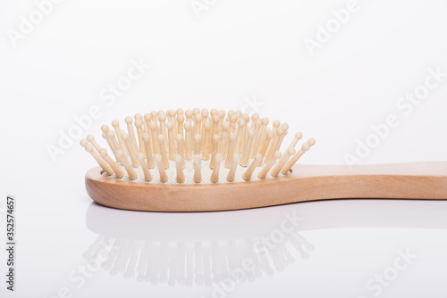 Close-up side profile view cropped photo of eco-friendly comb brush isolated on white background
