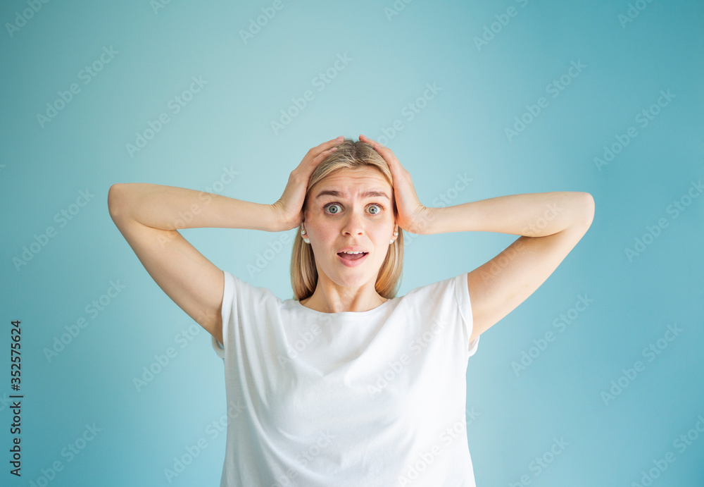 Shocked emotion. Portrait of a young woman looking amazed, hands on her head Shocked emotion. Portrait of a young woman looking amazed, hands on her head