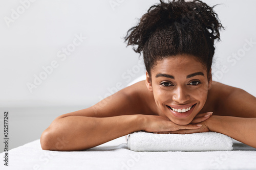 Close up of pretty black girl lying on massage table photo
