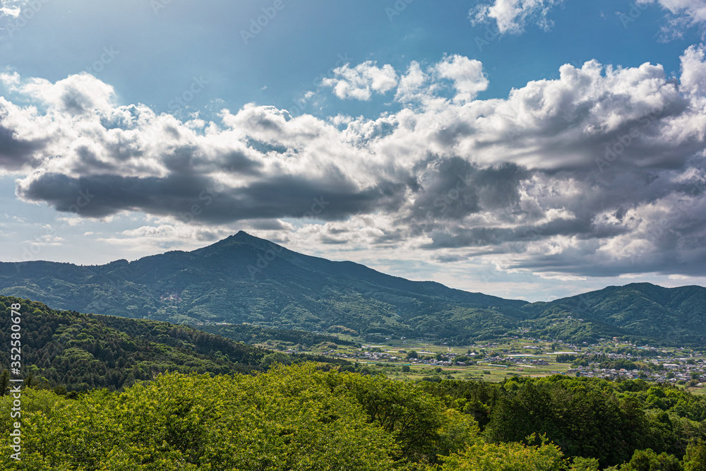 太陽光に照らされた大きな雲と新緑の里山 太陽光に照らされた大きな雲と新緑の里山