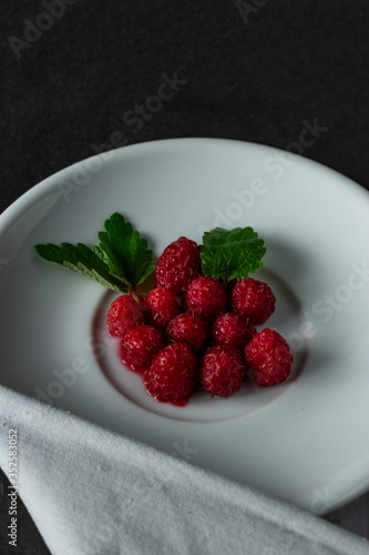 Raspberries with mint on a white platter