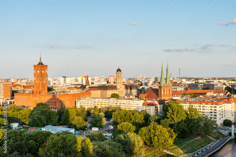 Cityscape of downtown of Berlin with the Red Town Hall and  tower of St. Nicholas' Church under sunset. Aerial view from Berlin Cathedral.