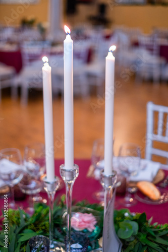 Close-up of candles standing on a table at a wedding reception. 