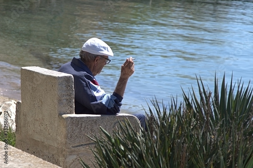 old man sitting on a pier