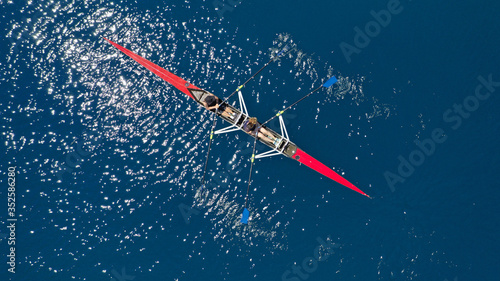 Aerial drone photo of women athletes exercising sport canoe in open ocean deep blue sea