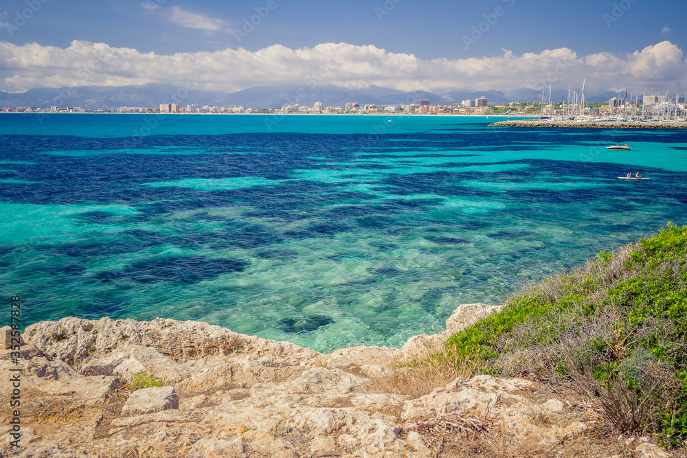 Colorful summer landscape with bay, boat, rocks, blue water, sky. Balearic islands Mallorca. View on Palma de Mallorca