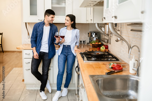 Couple drinking wine together in kitchen at home