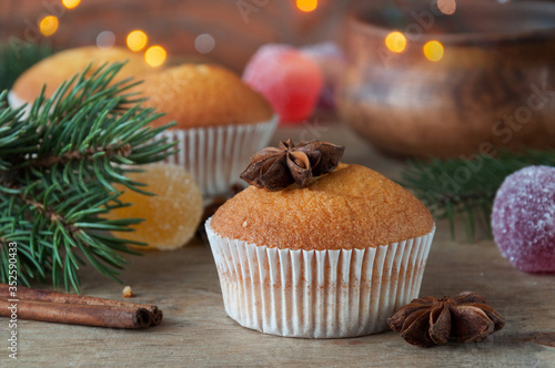 Delicious freshly baked muffins on a wooden table with star anise ready for graying with tea or coffee. Selective focus. Christmas spirit. Sweet dessert.
