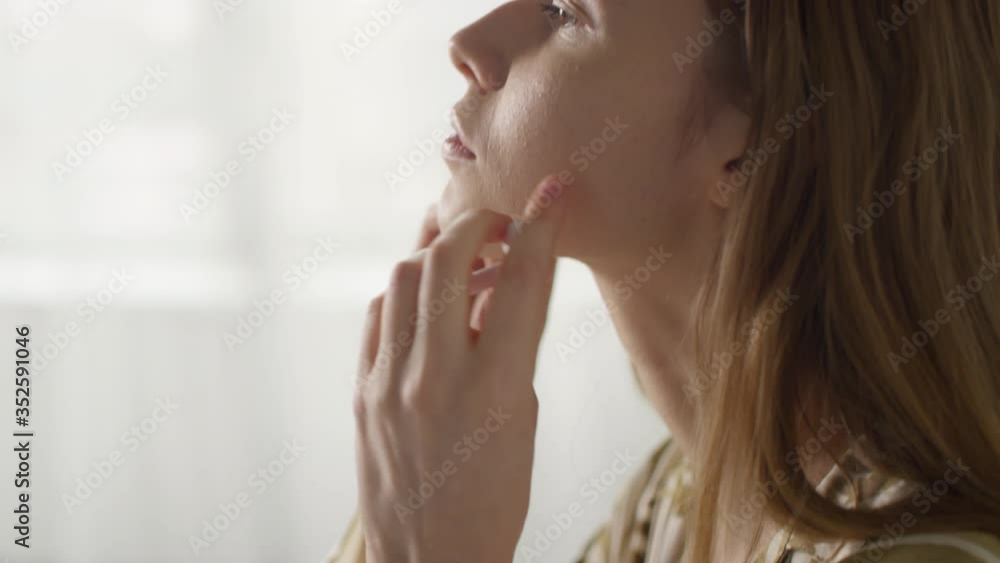 Slowmo close up with tilt up of beautiful young woman putting on wireless earphones and listening to music at home Slowmo close up with tilt up of beautiful young woman putting on wireless earphones and listening to music at home