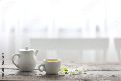 Fototapeta Naklejka Na Ścianę i Meble -  White tea cup and tea pot on wooden table minimal interior  