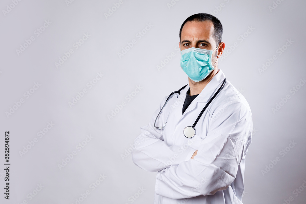 medico con camice bianco e mascherina chirurgica con braccia conserte isolato su sfondo bianco medico con camice bianco e mascherina chirurgica con braccia conserte isolato su sfondo bianco