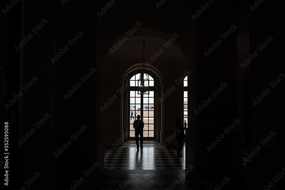 silueta de un hombre mirando por la ventana dentro de un cuarto oscuro