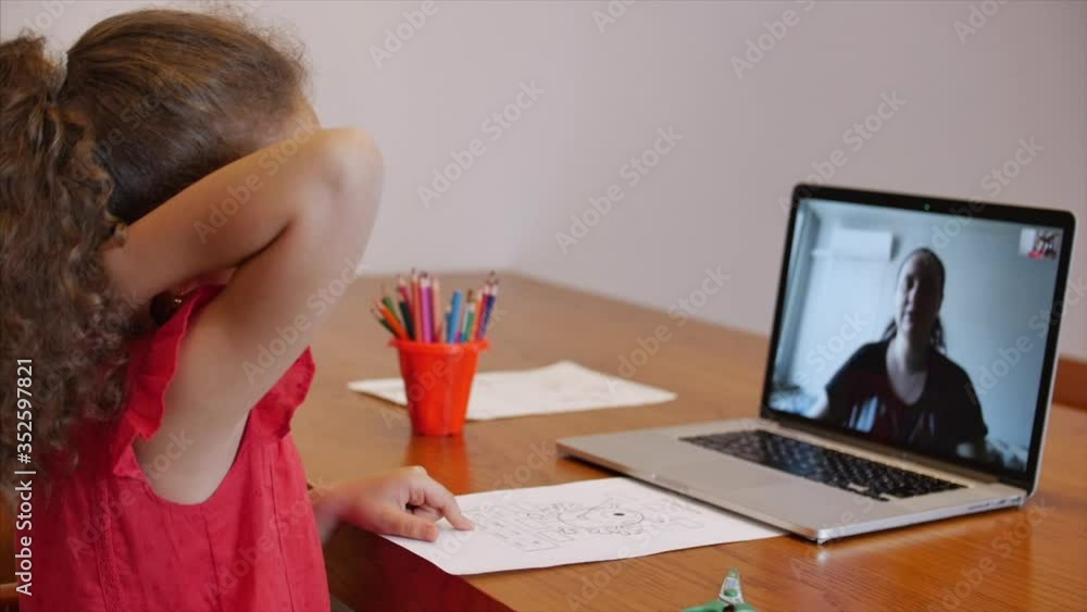 Distance Learning Online Education Schoolgirl Sits at home at her desk Performs a school assignment using a digital tablet device. School program Online lesson with a teacher on the computer. Distance Learning Online Education Schoolgirl Sits at home at her desk Performs a school assignment using a digital tablet device. School program Online lesson with a teacher on the computer.