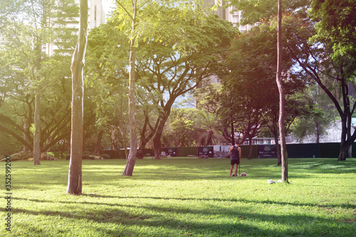 Almost empty Ayala triangle park where a guy walking dog, during coronavirus covid quarantine ECQ. Sunny day photo