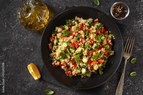Quadro su tela A plate with vegan refreshing couscous salad on back background