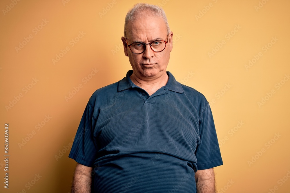 Middle age handsome hoary man wearing casual polo and glasses over yellow background depressed and worry for distress, crying angry and afraid. Sad expression. Middle age handsome hoary man wearing casual polo and glasses over yellow background depressed and worry for distress, crying angry and afraid. Sad expression.