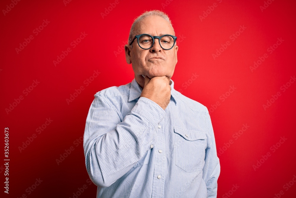Obraz premium Middle age handsome hoary man wearing casual striped shirt and glasses over red background Touching painful neck, sore throat for flu, clod and infection