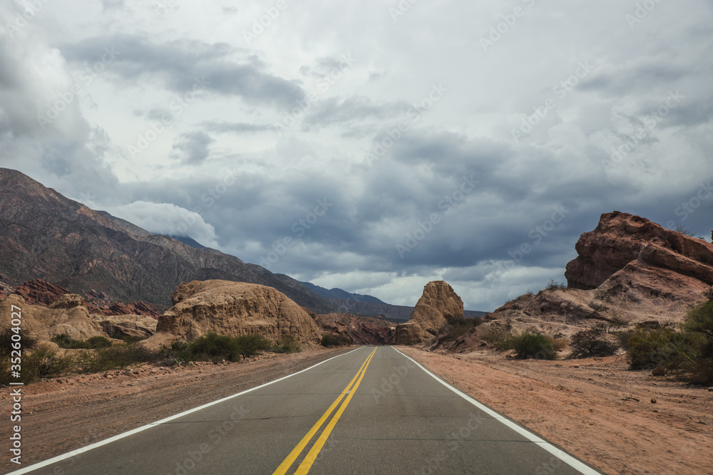 carretera o ruta por entre medio de las montañas en la naturaleza del norte argentino argentina jujuy con nuebes en el cielo