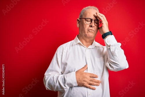 Middle age handsome hoary man wearing casual shirt and glasses over red background Touching forehead for illness and fever, flu and cold, virus sick