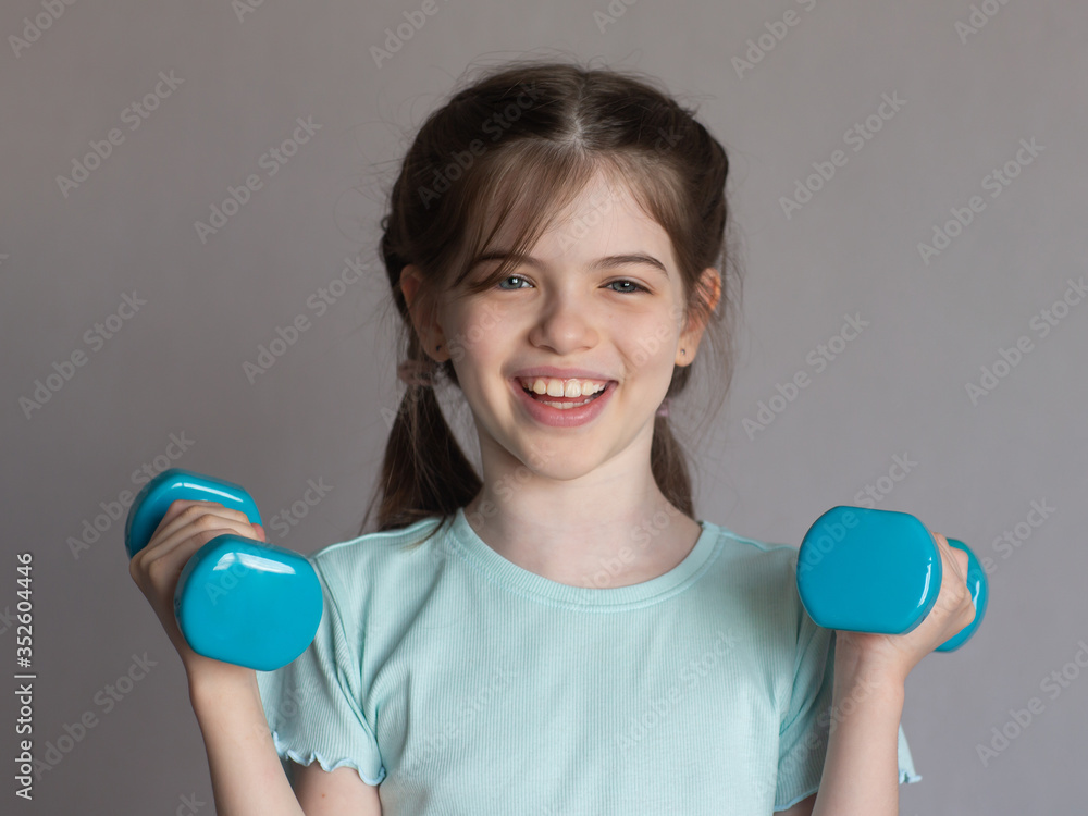 little happy girl holds dumbbells, child and sport, concept little happy girl holds dumbbells, child and sport, concept