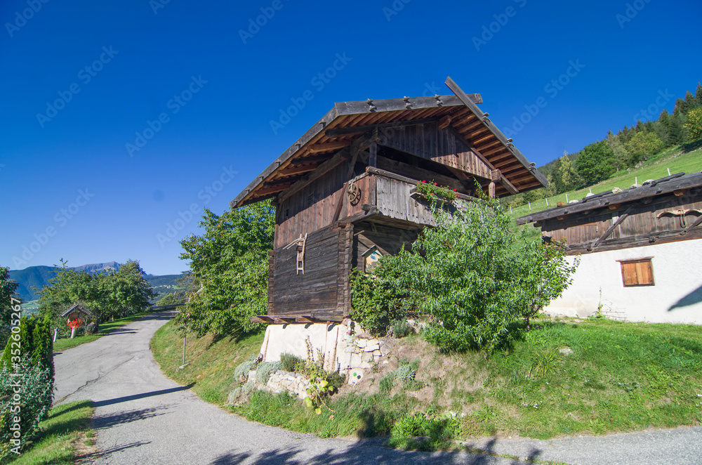 typical mountain building in stone, white plaster and wood and with colorful flowers typical mountain building in stone, white plaster and wood and with colorful flowers