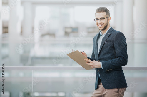 Smiling headhunter filling out candidate assessment after a job interview