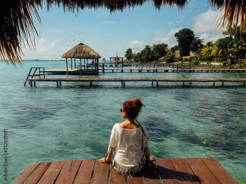  Chica de espaldas mirando al lago en Laguna Bacalar, Quintana Roo, Méjico. Agua turquesa. Vacaciones.