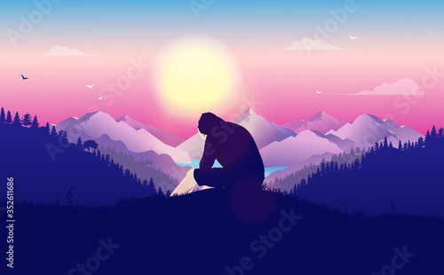 Man crying alone in landscape - Young male in hoodie sitting on hilltop with hands to his face. Beautiful landscape and view with sun in background. Unhappiness, feeling lost and outcast concept.
