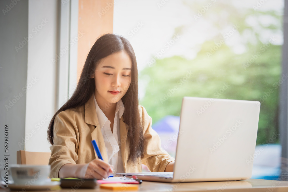 Portrait of Young asian businesswoman sitting indoors in cafe using digital tablet with coffee. Business success concept. Portrait of Young asian businesswoman sitting indoors in cafe using digital tablet with coffee. Business success concept.