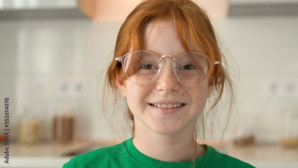 Smiley, freckles face, red-haired girl in eyeglasses looking at camera, giggling Smiley, freckles face, red-haired girl in eyeglasses looking at camera, giggling