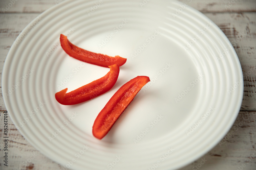 Bulgarian red pepper slices on white plate Bulgarian red pepper slices on white plate