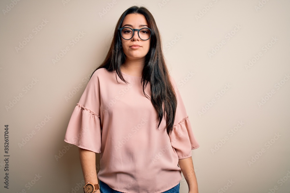 Young brunette elegant woman wearing glasses over isolated background Relaxed with serious expression on face. Simple and natural looking at the camera. Young brunette elegant woman wearing glasses over isolated background Relaxed with serious expression on face. Simple and natural looking at the camera.